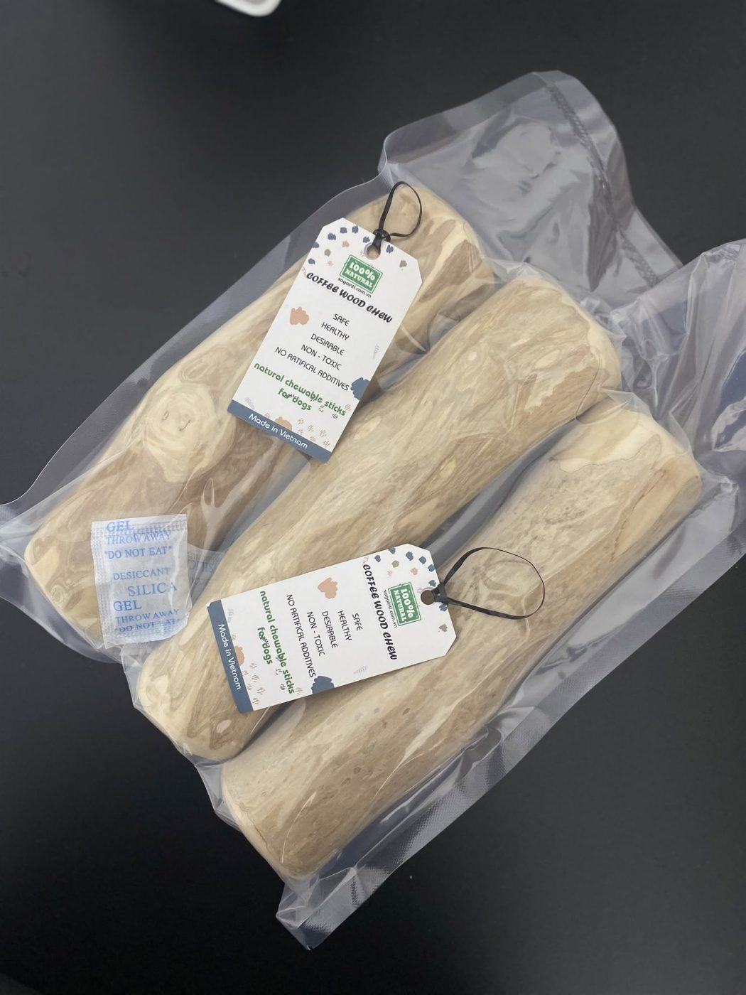 Coffee wood dog chews with hang tags telling the product story