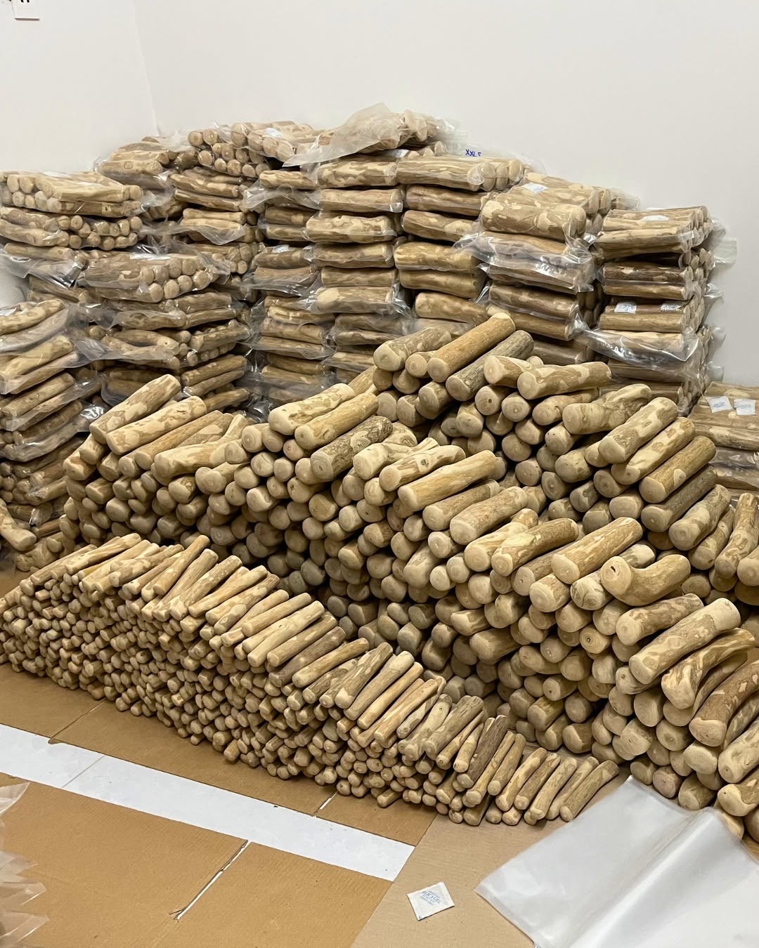Stacks of finished coffee wood chews and vacuum-packed bags ready for bulk orders